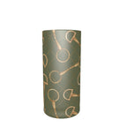 A tall, cylindrical shot glass with a muted sage green background and a repeating metallic gold pattern of horse bits and dotted diamond shapes, shown against a plain white background.