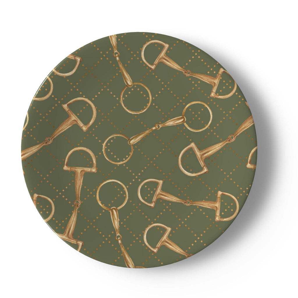 A round decorative plate featuring a repeating pattern of gold horse bits and rings on an olive green background with a subtle diamond lattice.