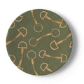 A round decorative plate featuring a repeating pattern of gold horse bits and rings on an olive green background with a subtle diamond lattice.