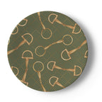 A round decorative plate featuring a repeating pattern of gold horse bits and rings on an olive green background with a subtle diamond lattice.
