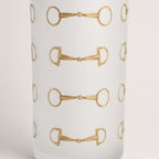 A closeup of a frosted shot glass  featuring a repeating horsebit pattern, shown against a clean white background.