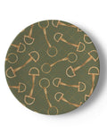 A round china dessert plate featuring an all-over pattern of gold horse bits on an olive green background with a subtle dotted diamond grid.