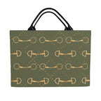 front of An olive green tote bag with a repeating pattern of gold horse bits and gold dots, featuring black shoulder straps, shown against a plain white background.