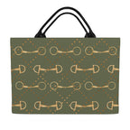 back of An olive green tote bag featuring a repeating pattern of gold horse bits and small gold dots, with black shoulder straps, shown against a plain white background.