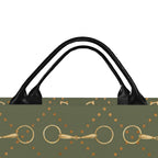 An olive green tote bag with black double leather shoulder straps, featuring a gold horse bit and gold dot pattern on a white background.